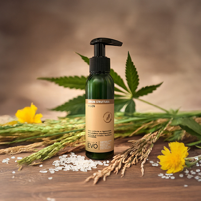 immagine del prodotto del serum struttura con sfondo marrone circondato da foglie verdi, spighe di riso e fiori gialli 